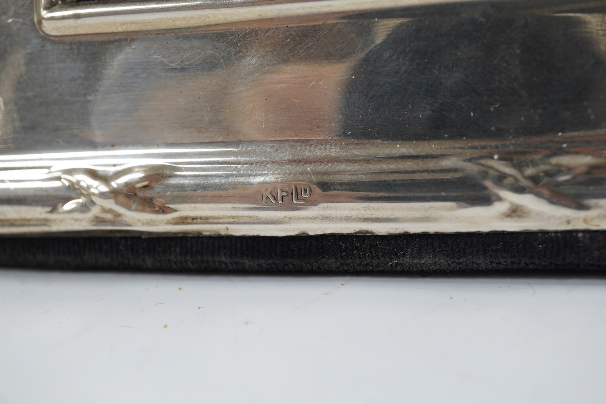 A George V silver two handled presentation trophy cup, 21.8cm, a modern silver wine coaster, a modern mounted silver photograph frame and a George V silver mounted photograph frame. Condition - poor to fair